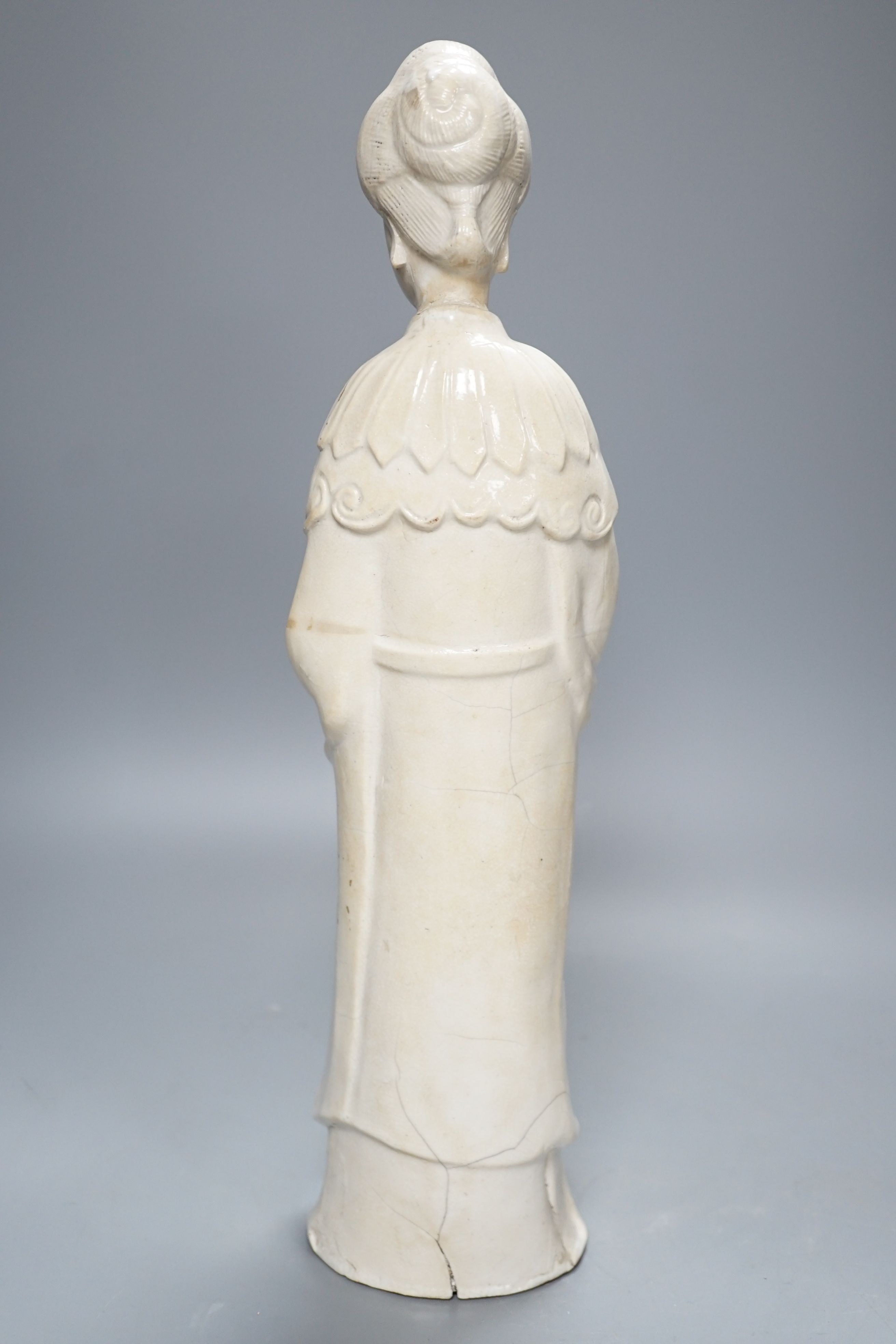 A Chinese blanc de chin figure of a lady with a bird, 37cm, together with a famille rose teapot, a yixing style teapot, blue and white jar and cover and a pale celadon ground ‘ox head’ libation cup